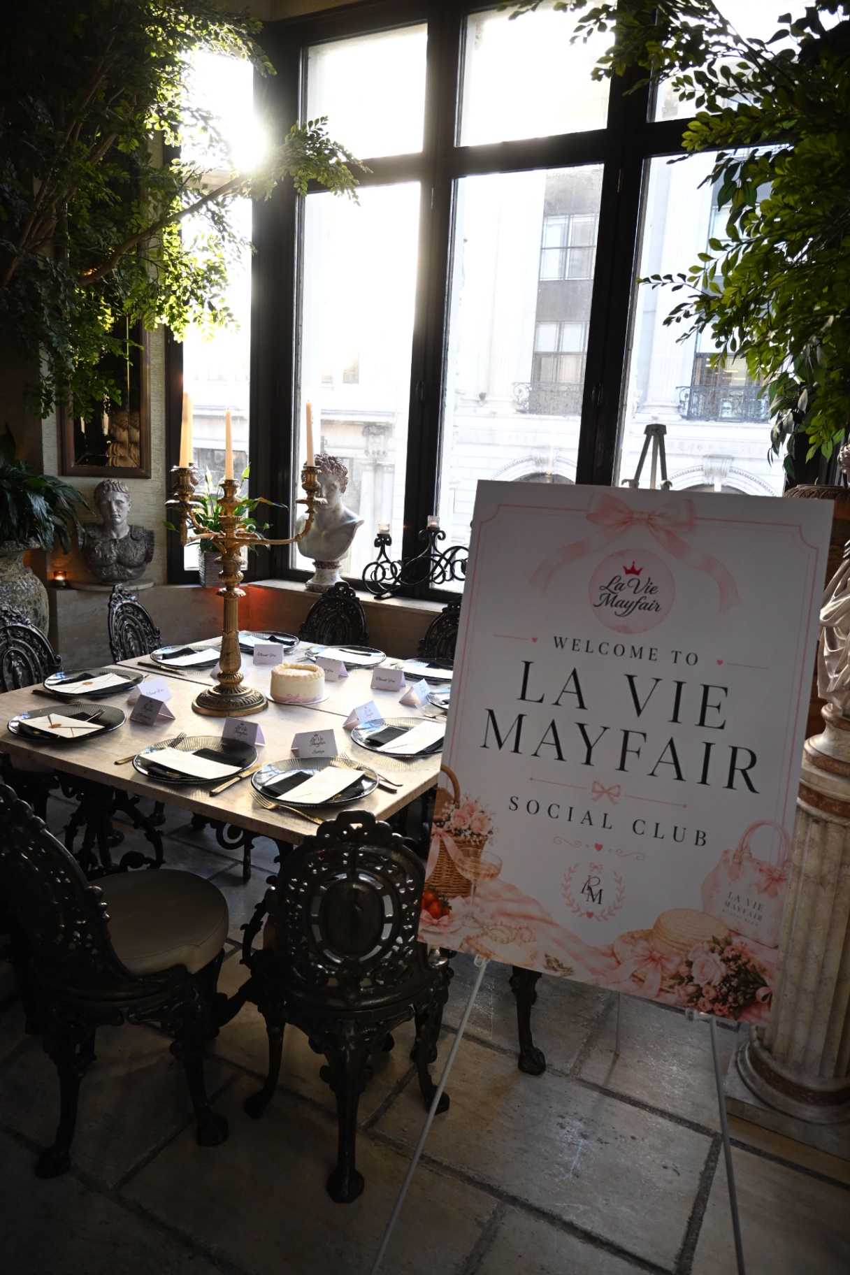 The welcome sign and candlelit table set for the La Vie Mayfair dinner at Sheesh Mayfair