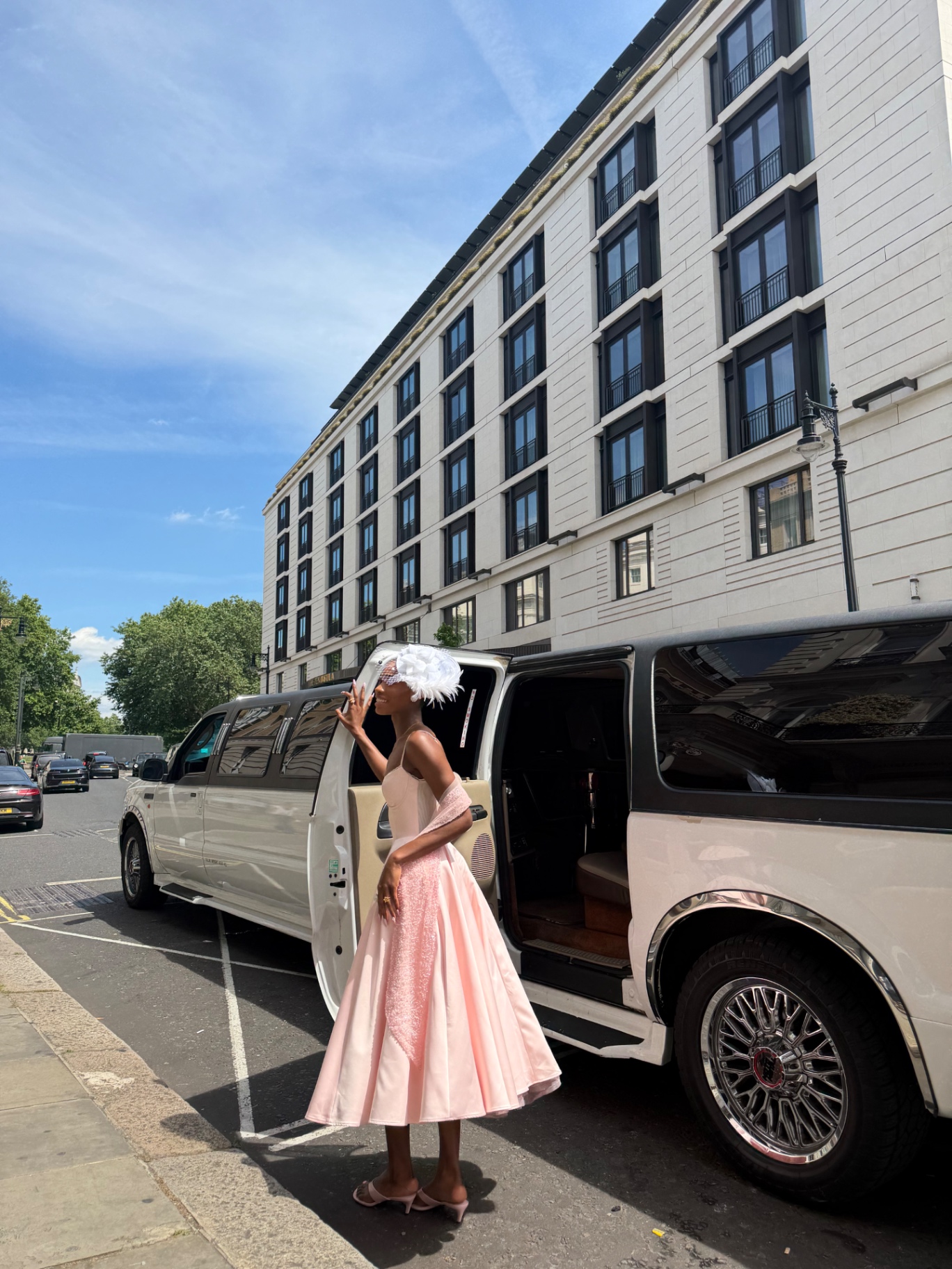 A member in a pink gown stepping into the limousine in Mayfair