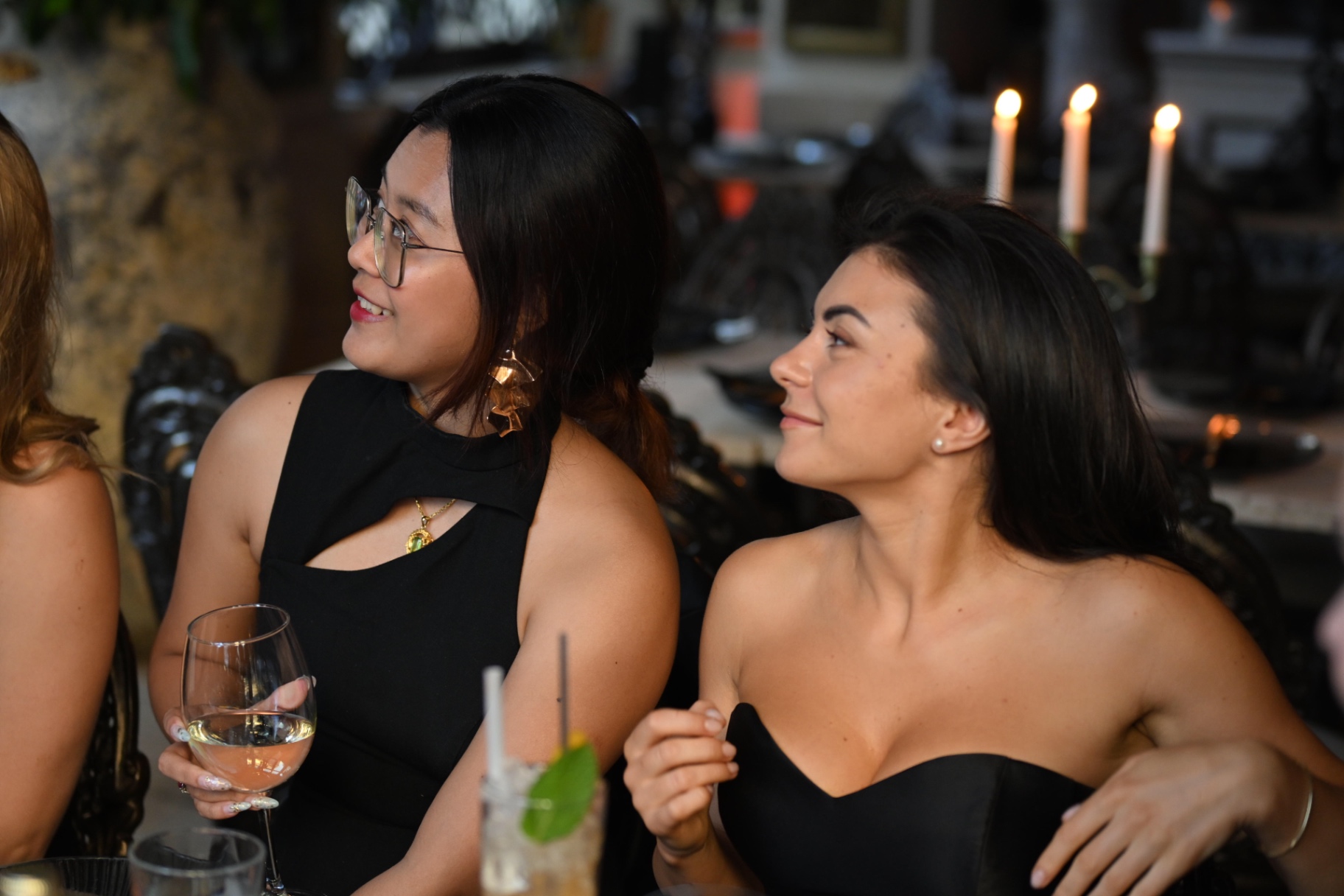 Two members smiling together by the candelabra