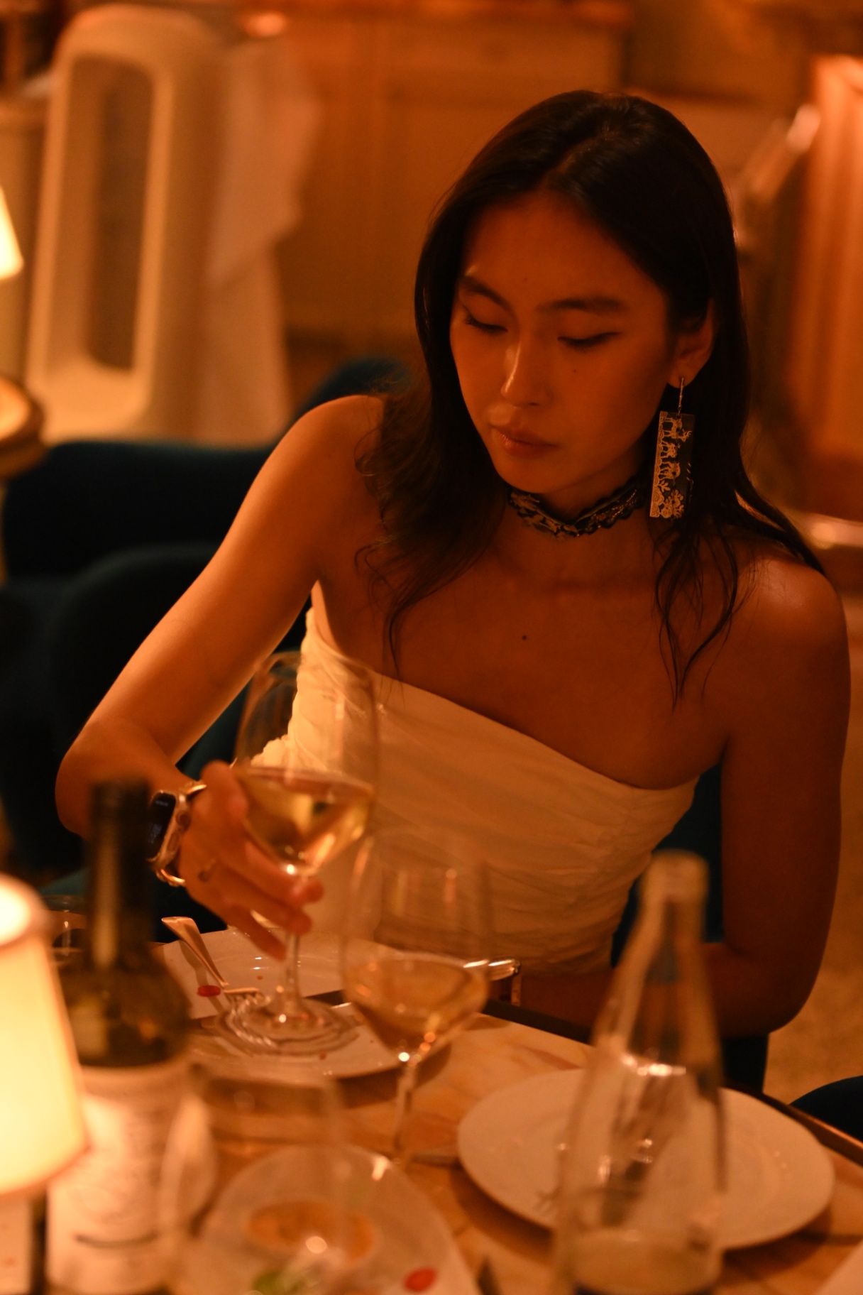 A member reaching for her wine glass at the dinner table