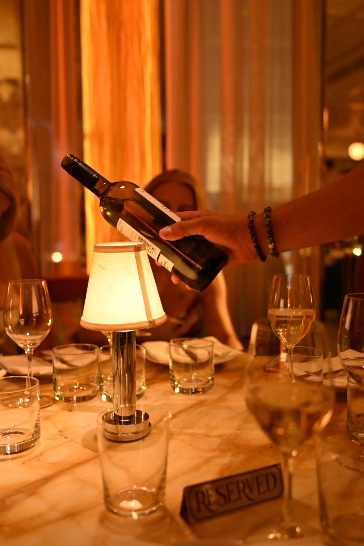 Wine being poured at the candlelit dinner table