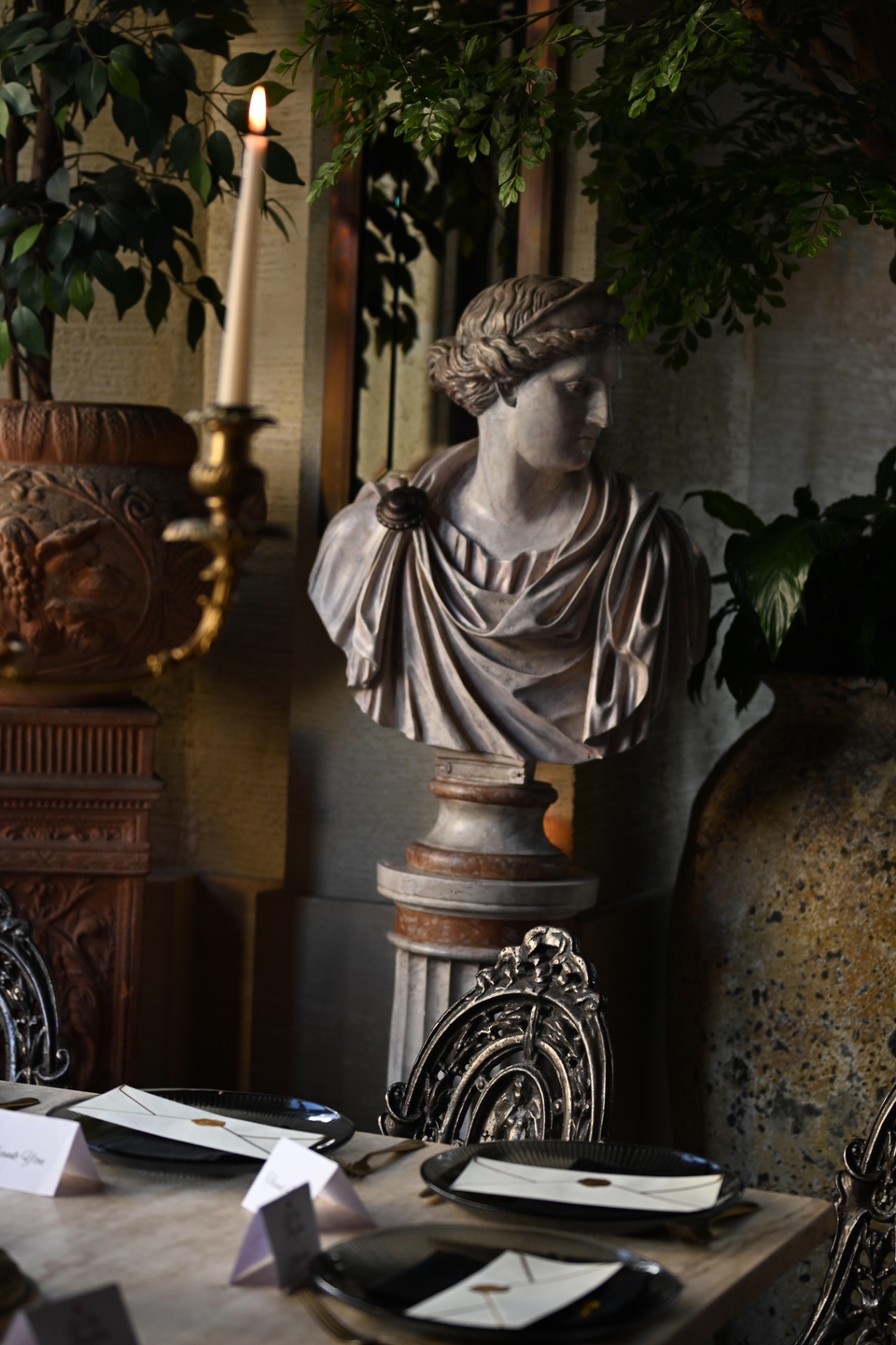 A marble bust and candlelight beside the dinner table
