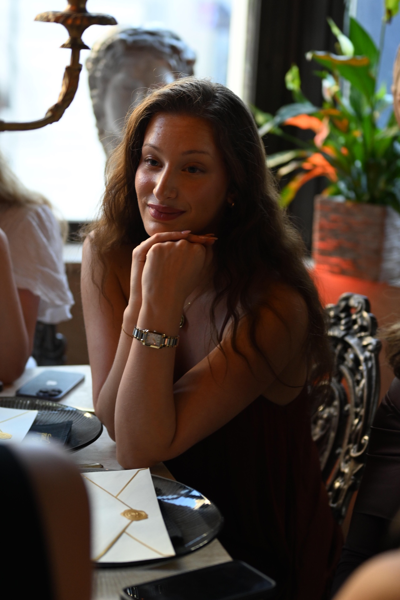 A member resting her chin on her hand at the dinner table