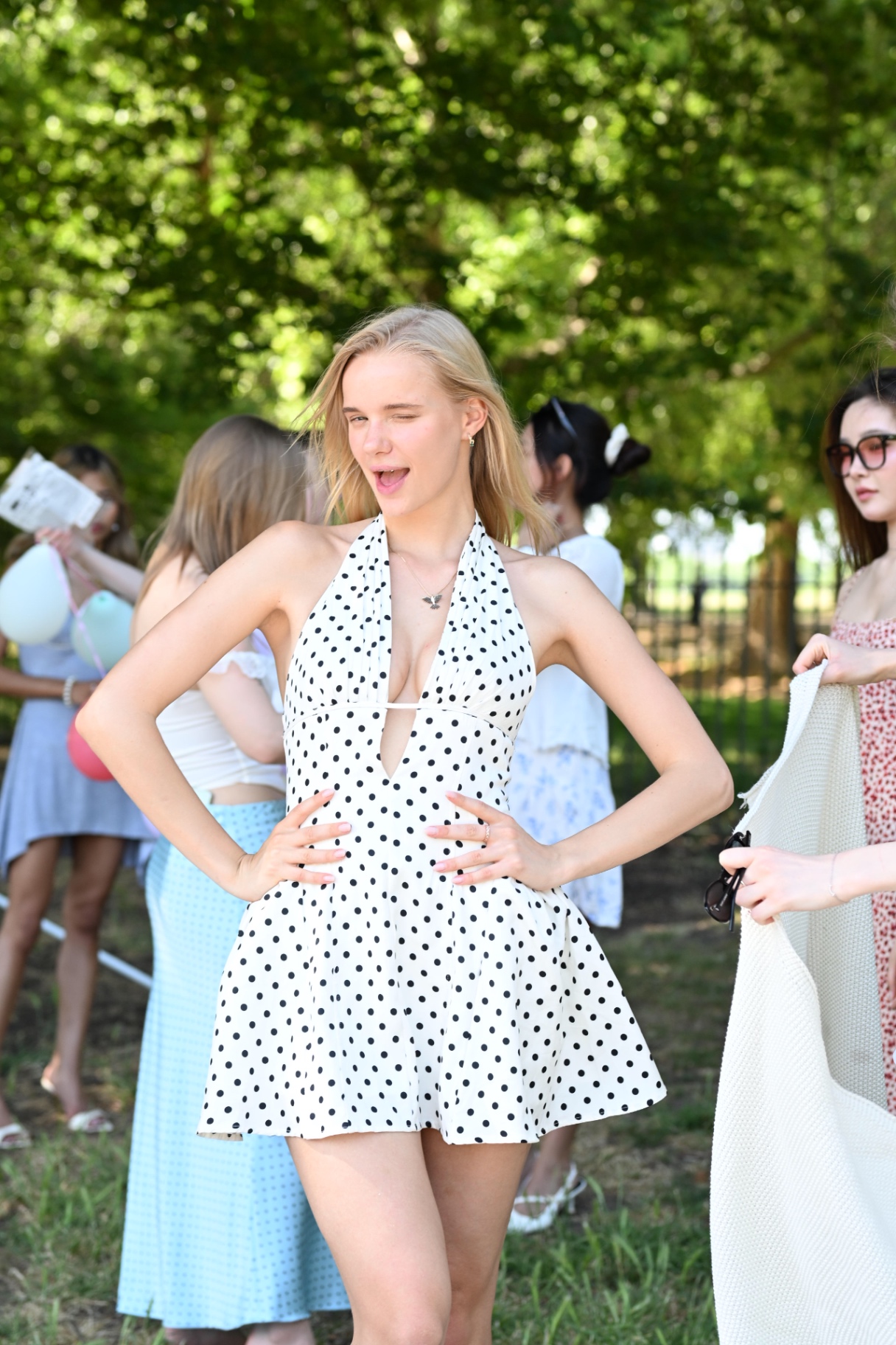 A member in a polka dot dress laughing at the spring picnic