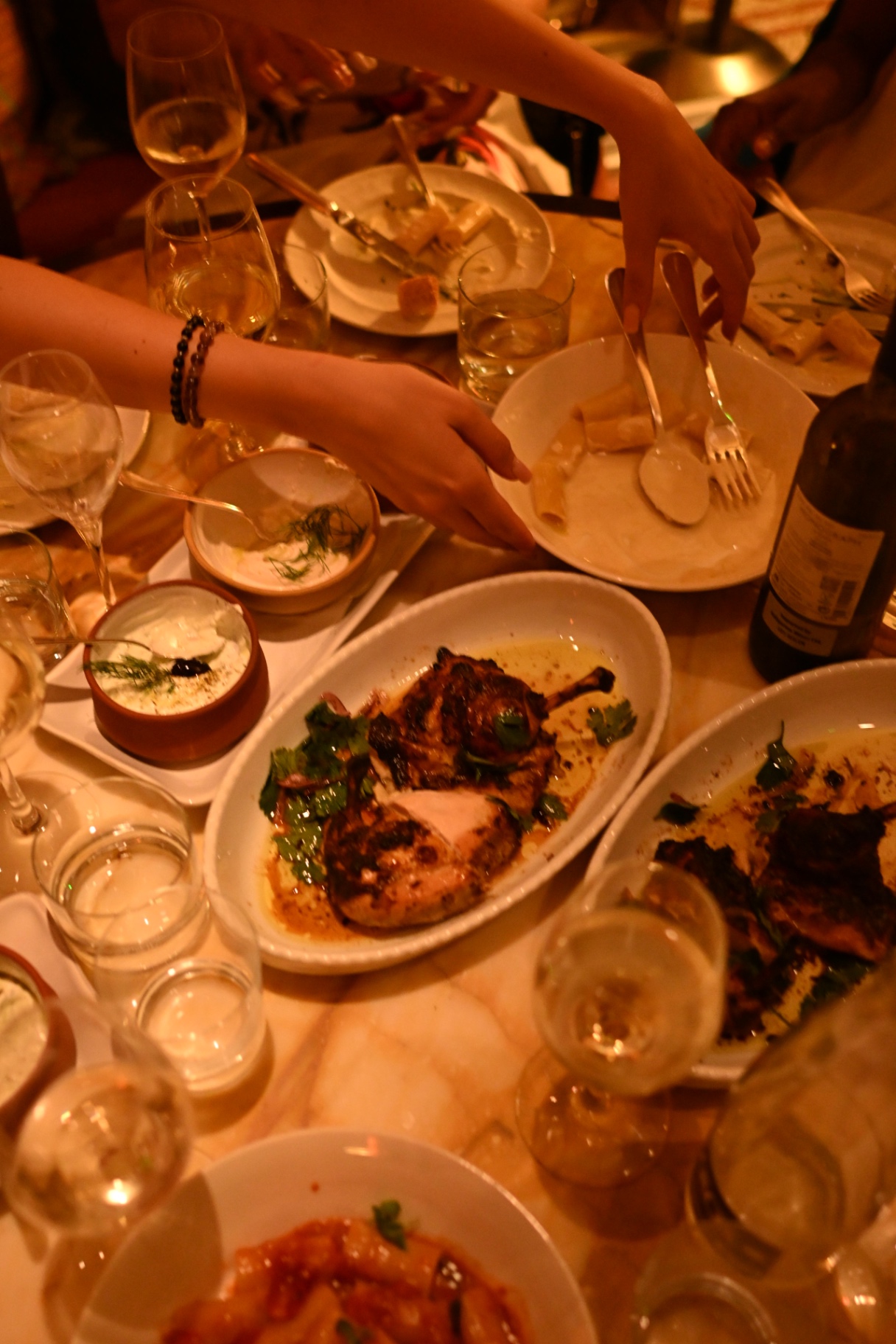 Shared mains and mezze spread across the marble table