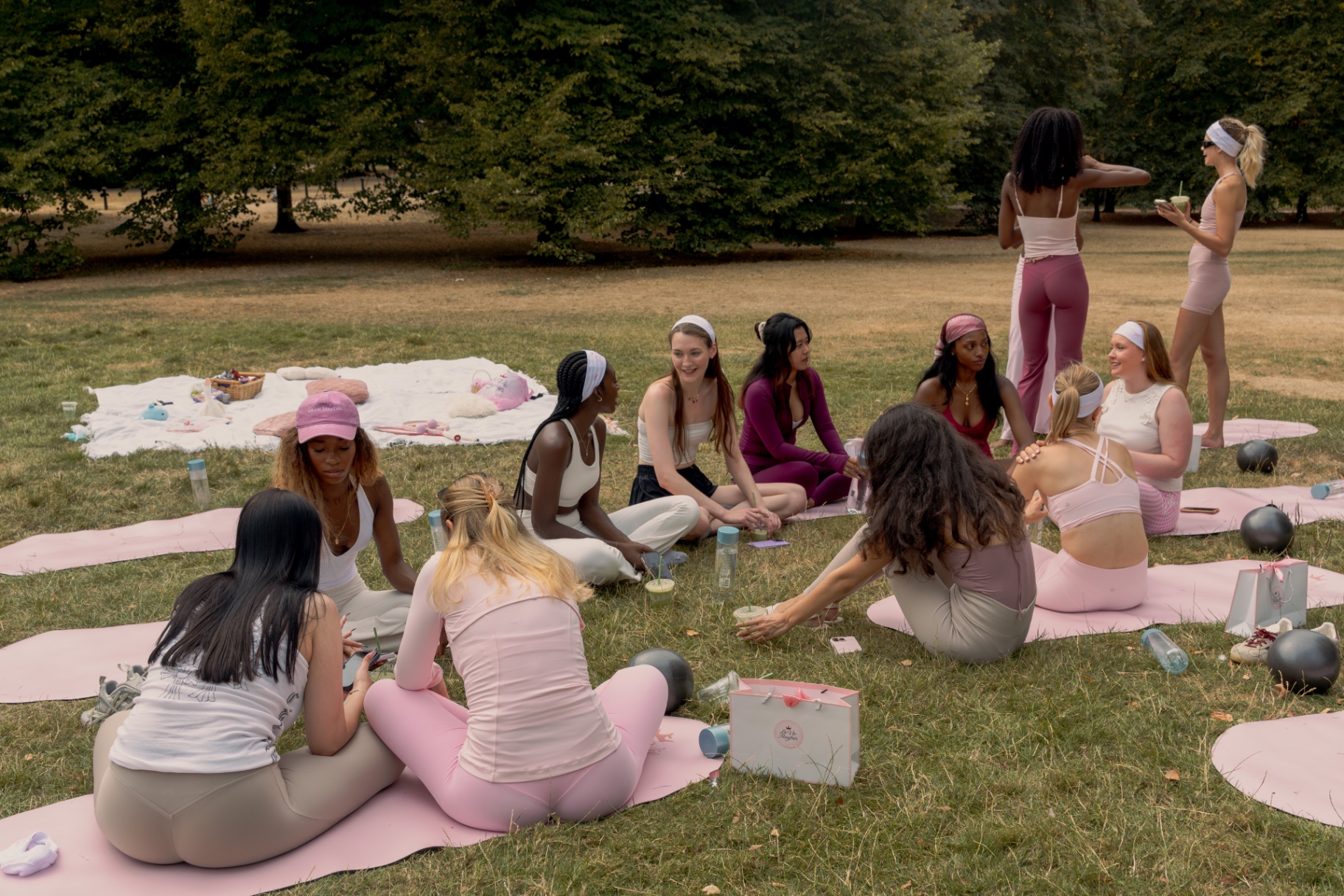 Members seated on their mats during the Hersomastudio Pilates session in the park