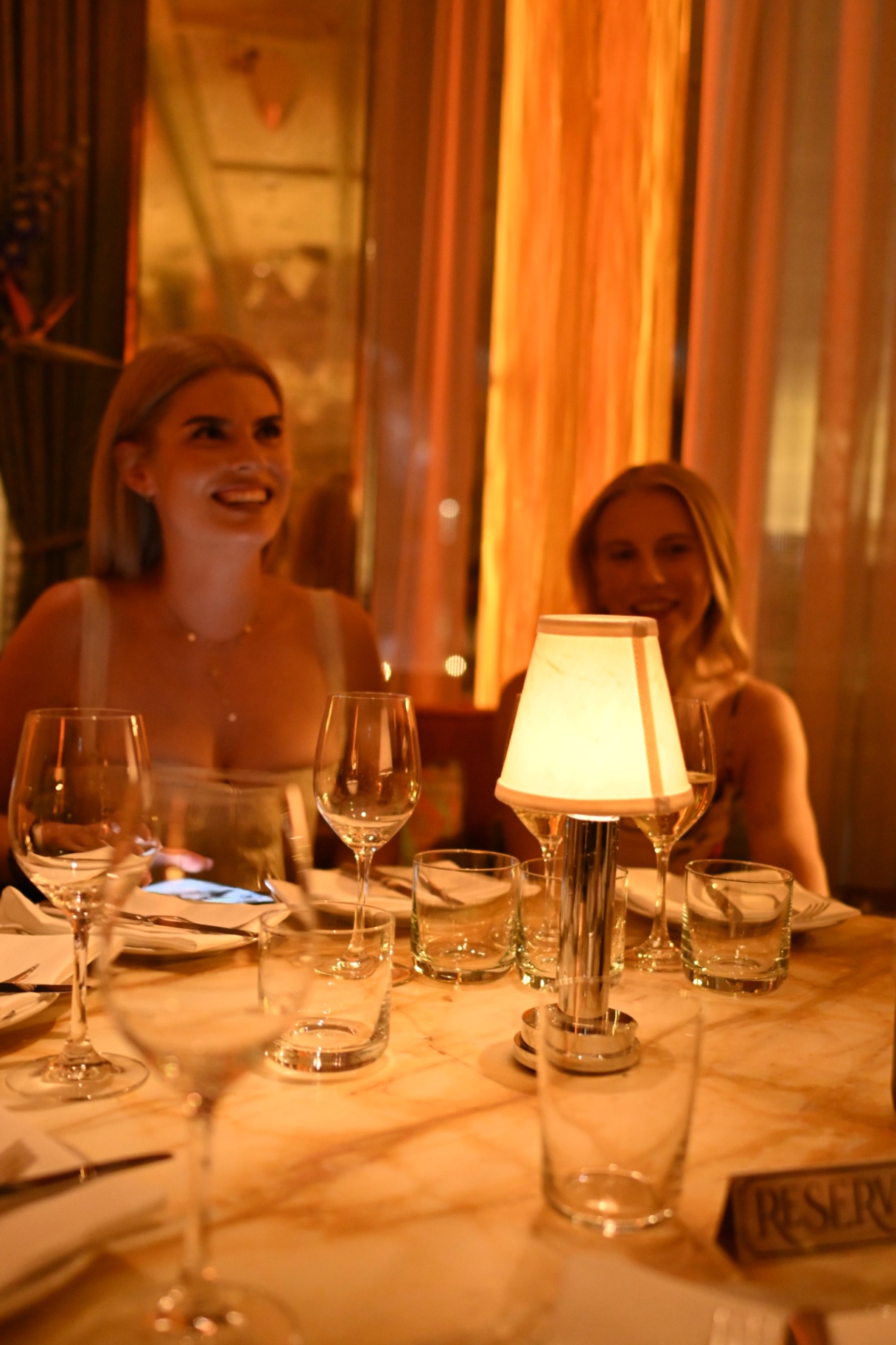 Members laughing by candlelight at the dinner table