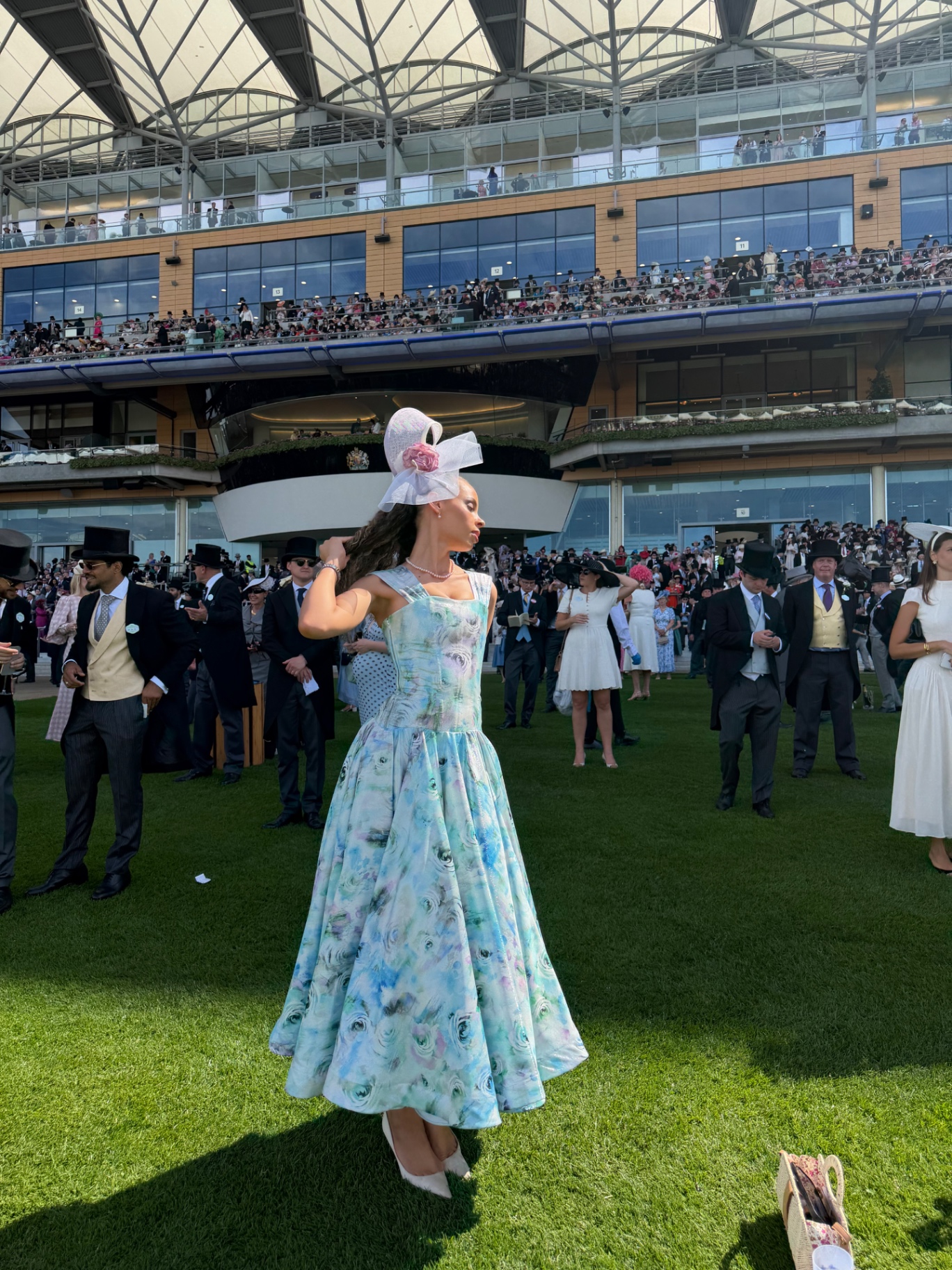 A member twirling in a watercolour floral gown in front of the grandstand