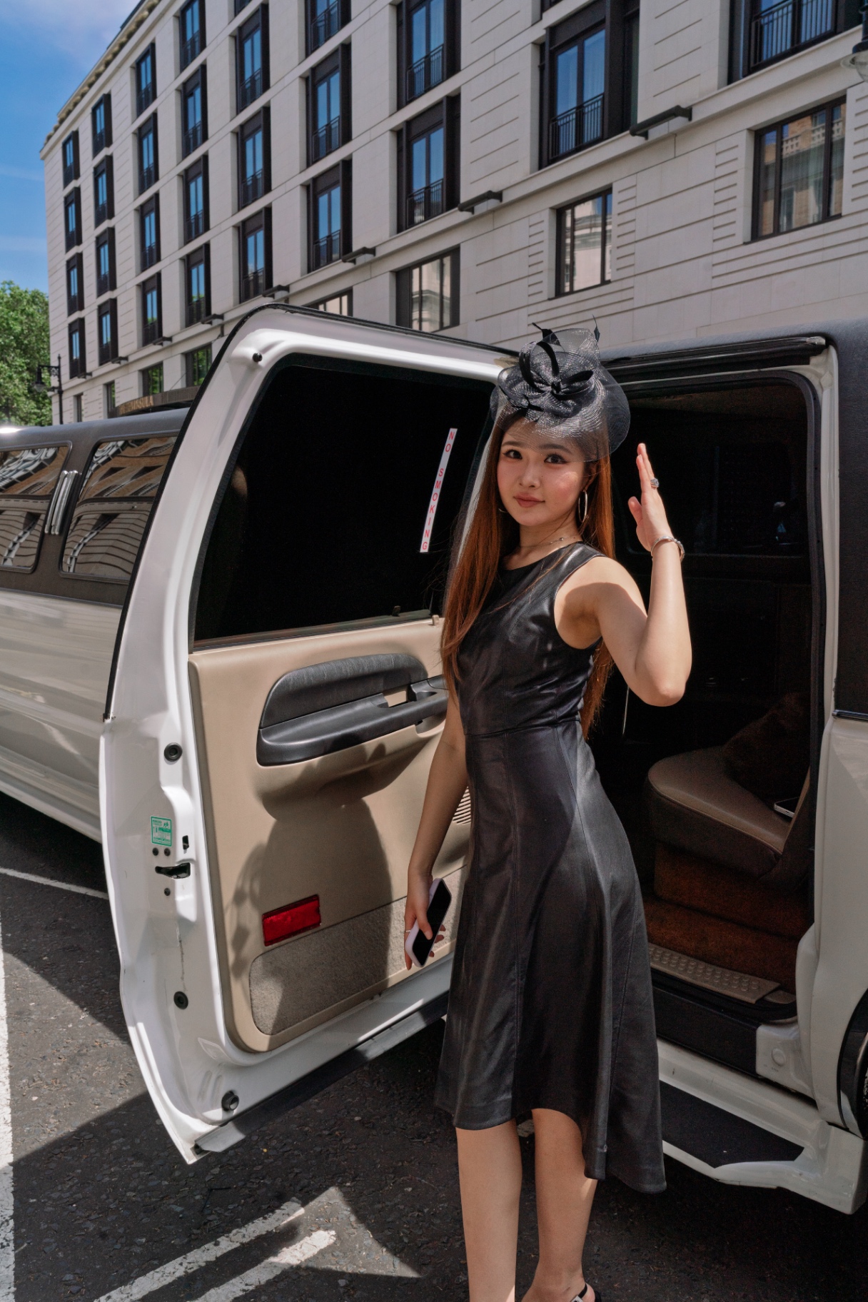 A member waving as she steps out of the limousine in Mayfair